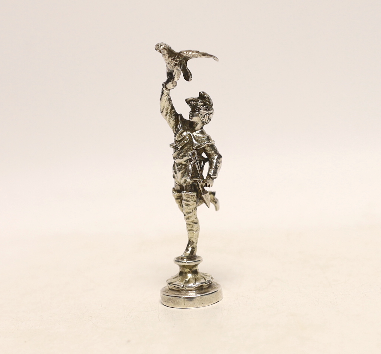 A late Victorian silver miniature model of a Falconer, on a circular base, import marks for Berthold Muller, London, 1897, 9cm.